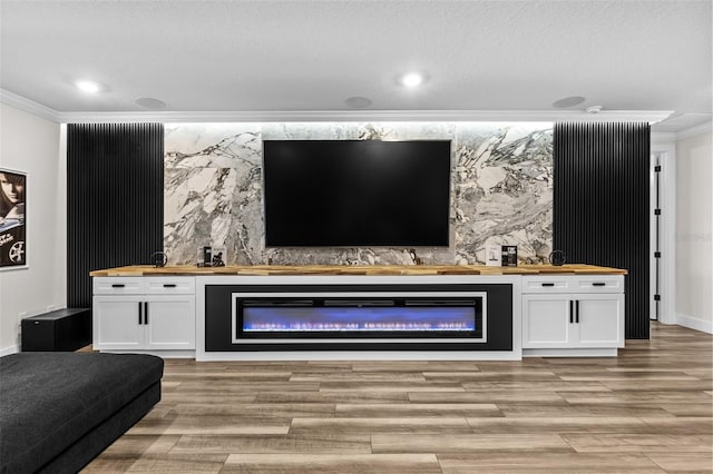 living room with crown molding, a textured ceiling, and light wood-type flooring