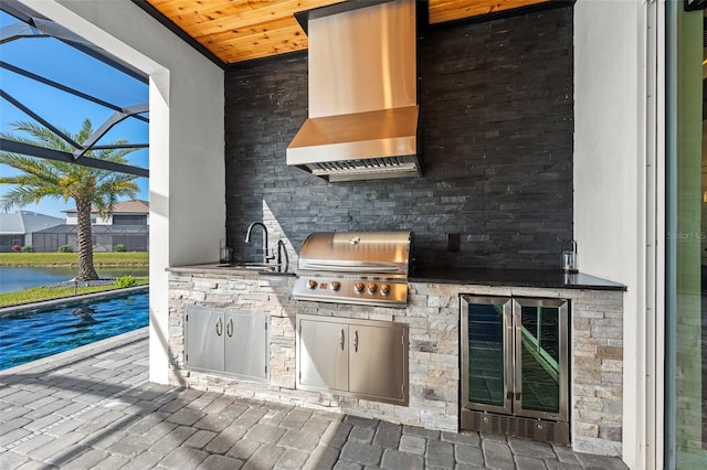 view of patio / terrace with an outdoor kitchen, a grill, sink, wine cooler, and a lanai