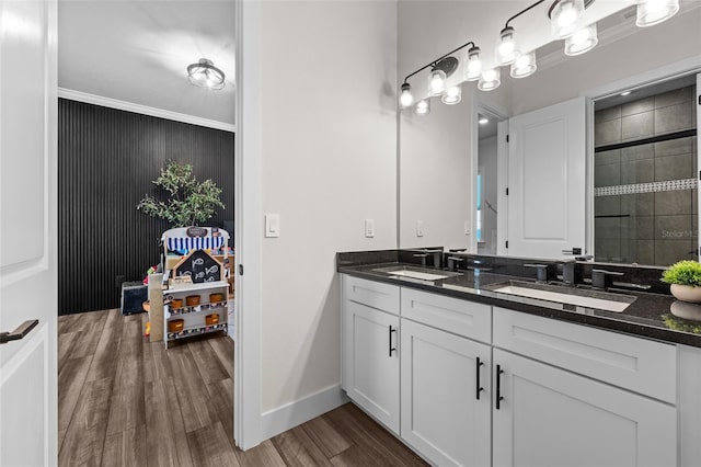 bathroom with vanity, crown molding, wood-type flooring, and a shower with door