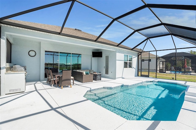 pool featuring exterior kitchen, an outdoor hangout area, a lanai, and a patio area