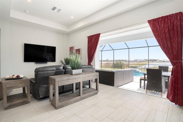 living area with recessed lighting, visible vents, a raised ceiling, and a sunroom