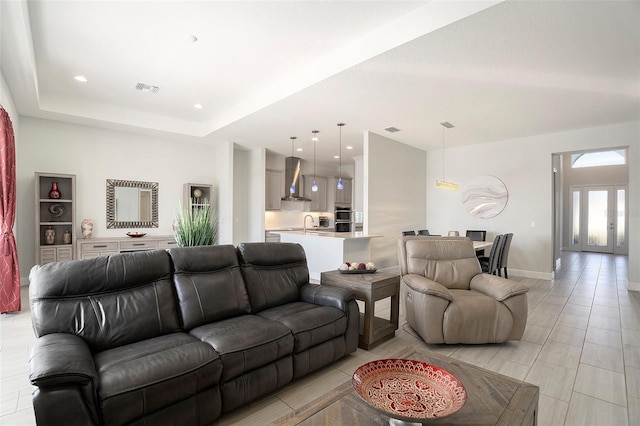 living area with visible vents, recessed lighting, baseboards, french doors, and a raised ceiling