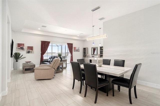 dining room with visible vents, recessed lighting, a tray ceiling, and baseboards