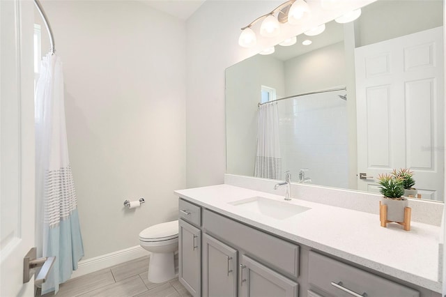 full bathroom with vanity, curtained shower, toilet, and baseboards