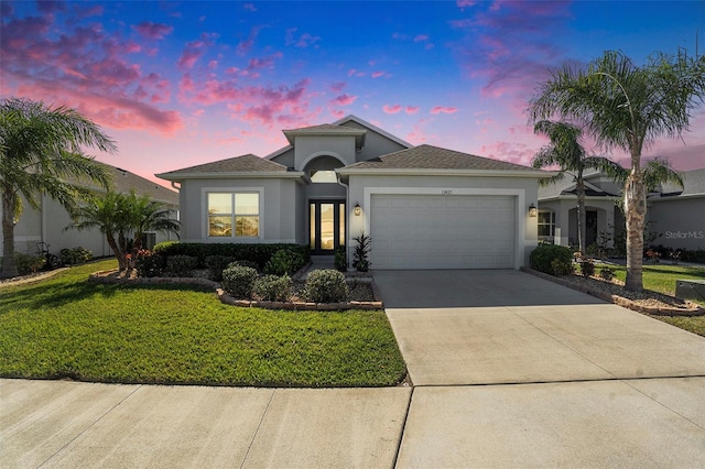 ranch-style home with stucco siding, an attached garage, concrete driveway, and a front lawn