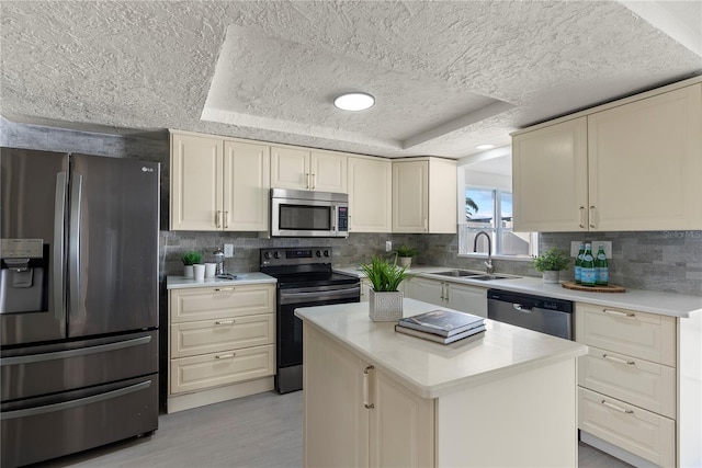 kitchen featuring sink, backsplash, stainless steel appliances, a kitchen island, and a raised ceiling