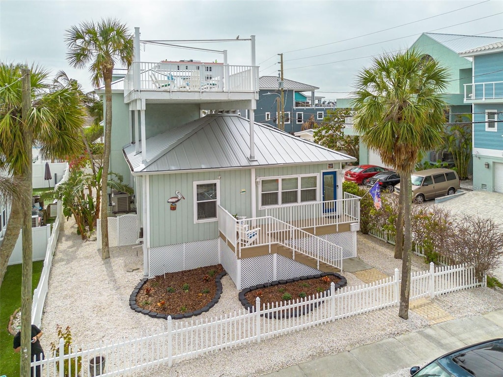 view of front of house with a standing seam roof, metal roof, and a fenced front yard