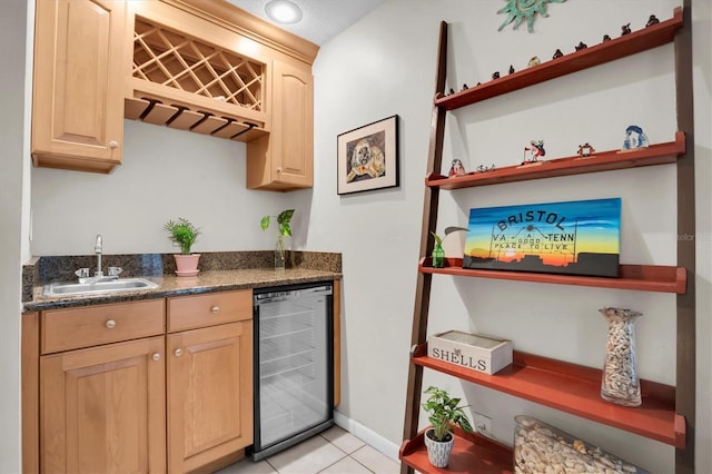 bar with beverage cooler, light brown cabinetry, sink, and light tile patterned floors