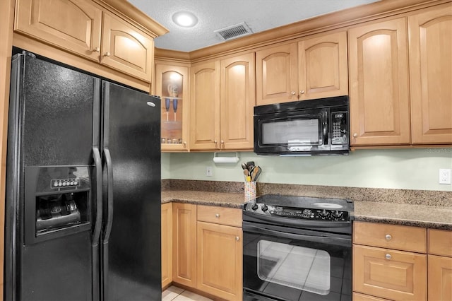 kitchen with a textured ceiling, light brown cabinetry, dark stone counters, and black appliances