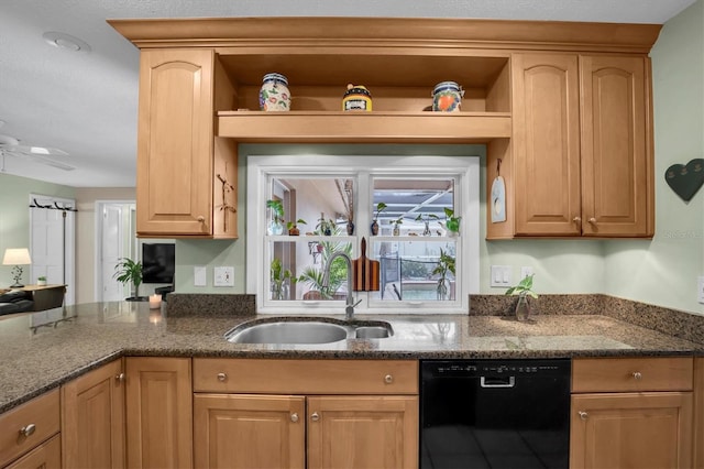 kitchen featuring dark stone counters, light brown cabinetry, black dishwasher, and sink