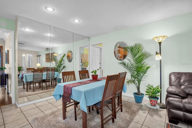 tiled dining space featuring a textured ceiling