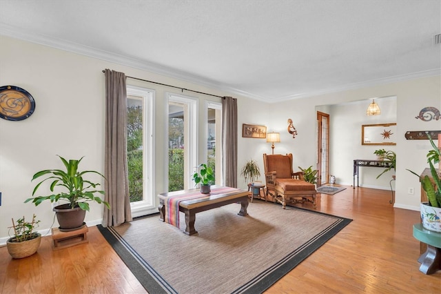 sitting room with hardwood / wood-style flooring and ornamental molding