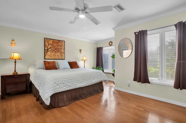 bedroom with crown molding, ceiling fan, and light hardwood / wood-style floors