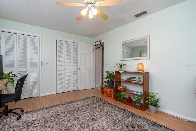 office with ceiling fan, hardwood / wood-style flooring, and a textured ceiling