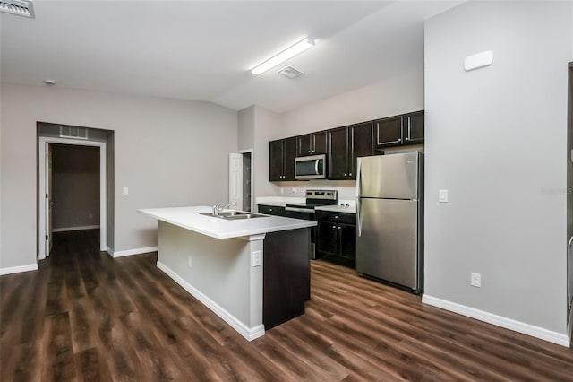 kitchen featuring lofted ceiling, sink, dark hardwood / wood-style flooring, stainless steel appliances, and a kitchen island with sink