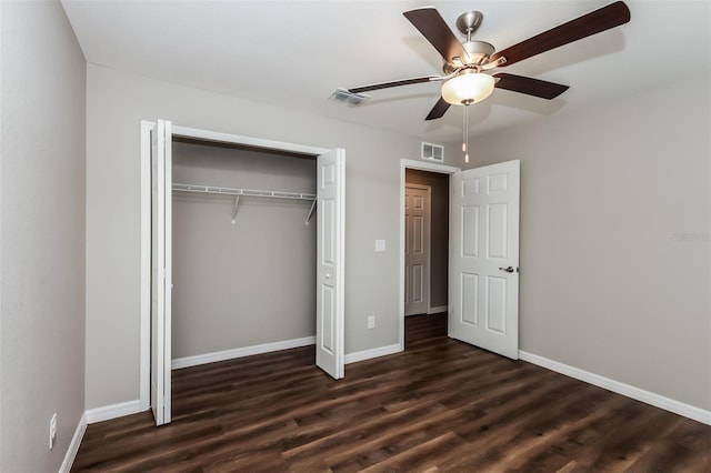 unfurnished bedroom with dark wood-type flooring, a closet, and ceiling fan