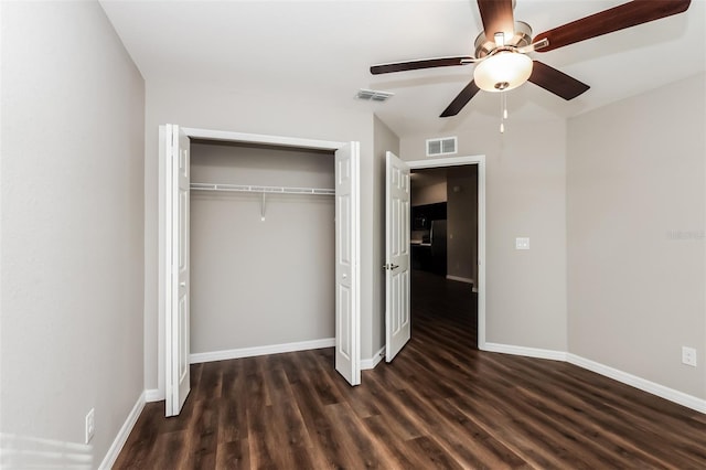 unfurnished bedroom with dark hardwood / wood-style flooring, ceiling fan, and a closet