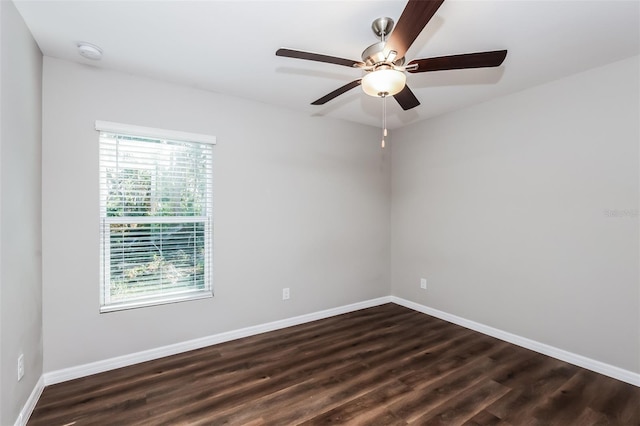 spare room featuring dark wood-type flooring and ceiling fan