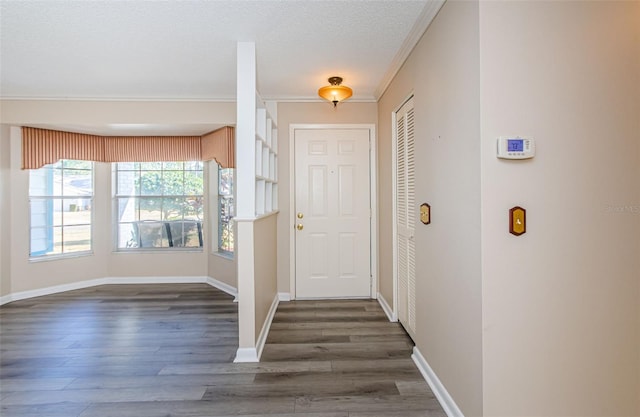 entrance foyer with dark hardwood / wood-style flooring, ornamental molding, and a textured ceiling