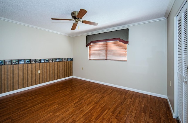 empty room with crown molding, dark wood-type flooring, ceiling fan, and a textured ceiling