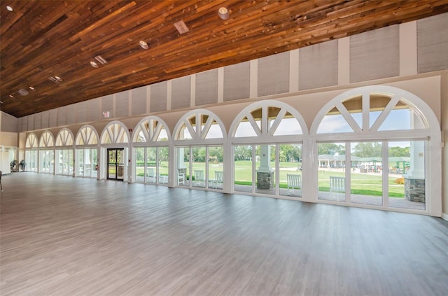 unfurnished room with hardwood / wood-style flooring, wood ceiling, and high vaulted ceiling