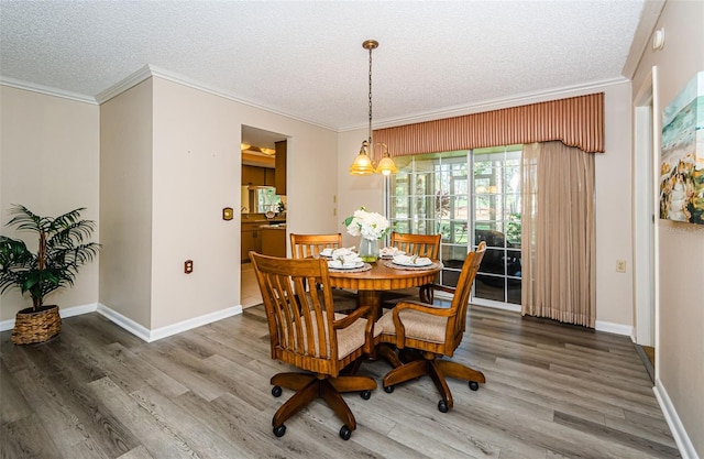 dining area featuring hardwood / wood-style floors, ornamental molding, and a textured ceiling