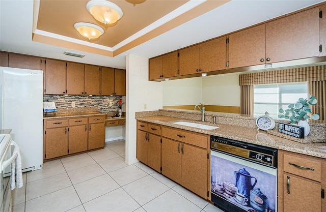 kitchen with sink, a tray ceiling, dishwashing machine, white fridge, and stove