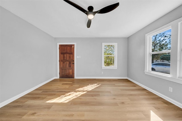 empty room with ceiling fan and light hardwood / wood-style flooring