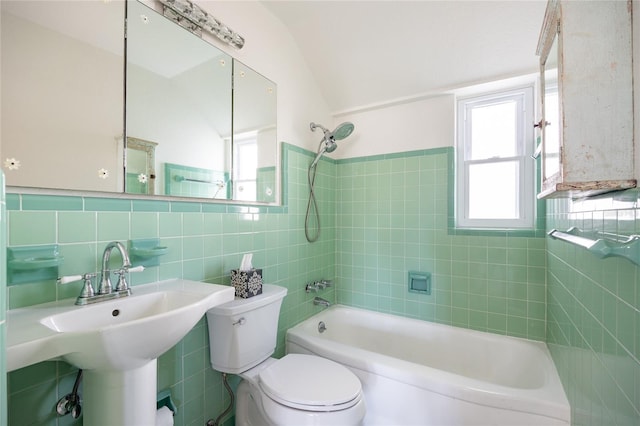 full bathroom featuring a healthy amount of sunlight, toilet, shower / bath combination, and tile walls