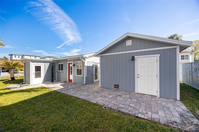 rear view of property featuring an outbuilding and a lawn