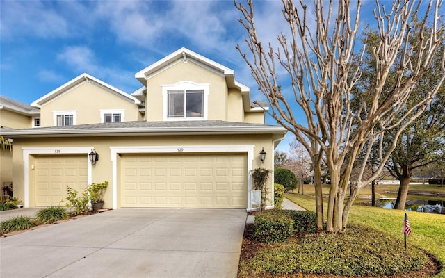 view of property featuring a garage and a front lawn