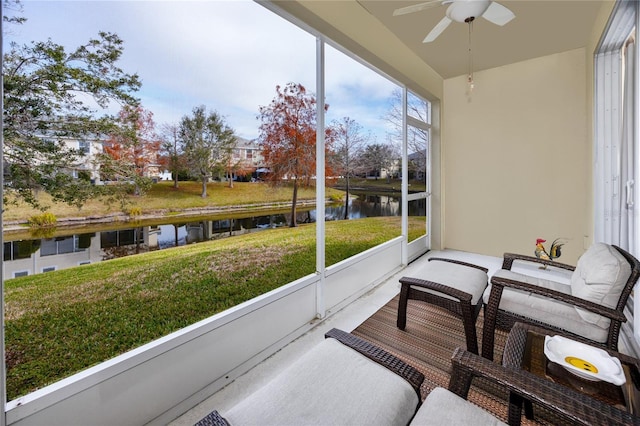 sunroom / solarium featuring a water view and ceiling fan