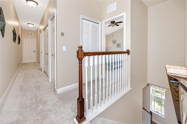 hallway featuring light colored carpet