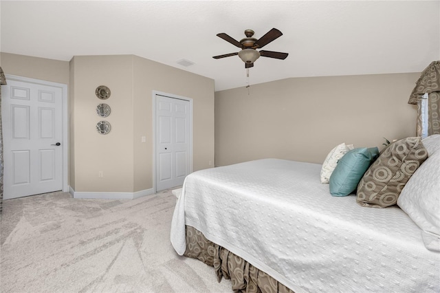 carpeted bedroom with ceiling fan, vaulted ceiling, and a closet