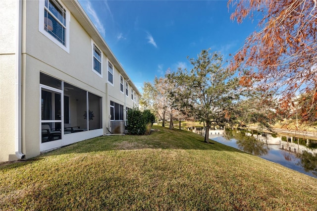 view of yard featuring a water view and central AC