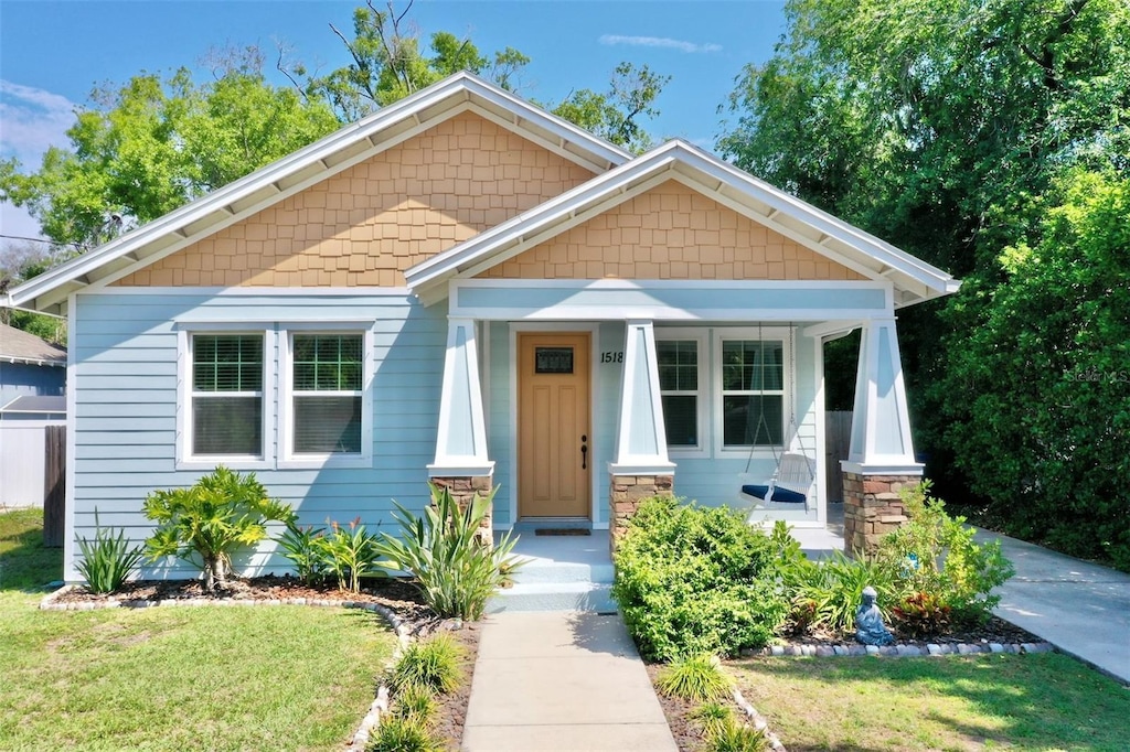 view of front of house featuring covered porch and a front yard