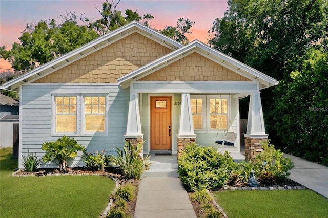 view of front of home featuring a porch and a yard