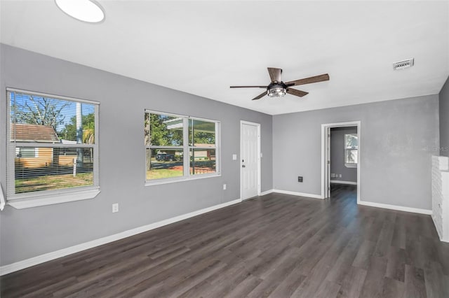 unfurnished living room with dark hardwood / wood-style floors, a wealth of natural light, and ceiling fan