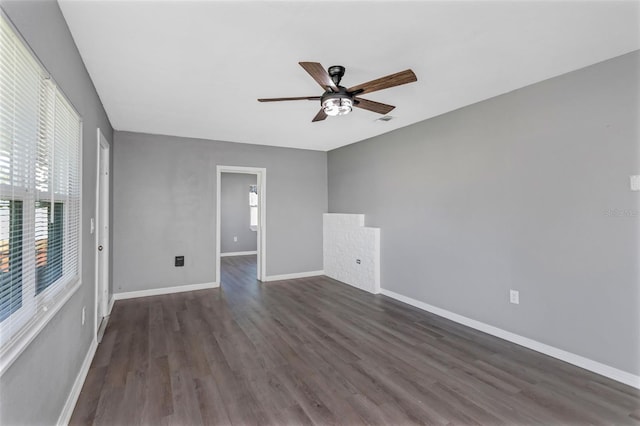 spare room with dark wood-type flooring and ceiling fan