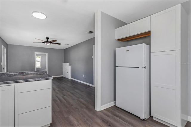 kitchen with ceiling fan, white fridge, white cabinets, and dark hardwood / wood-style flooring