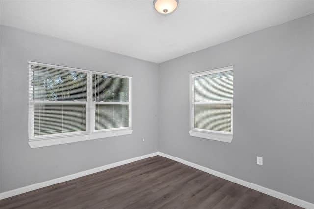 empty room featuring dark wood-type flooring and plenty of natural light