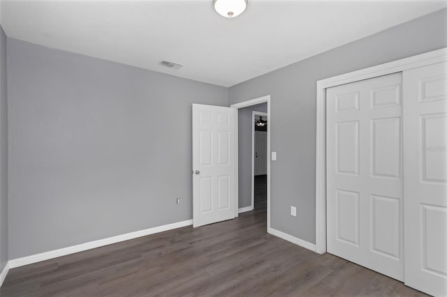 unfurnished bedroom featuring dark hardwood / wood-style floors and a closet