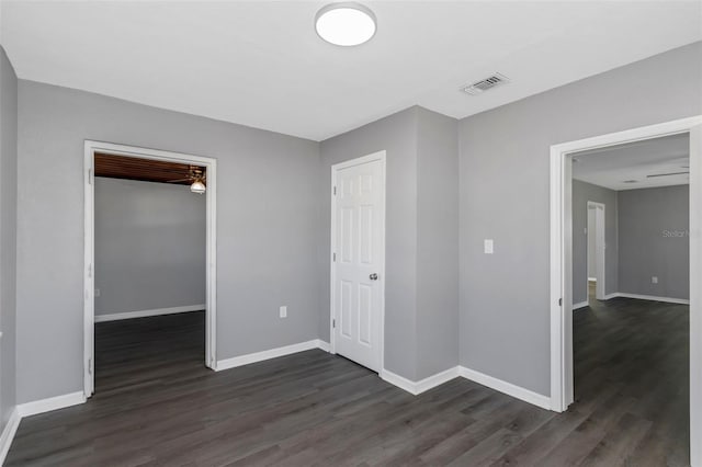 unfurnished bedroom with a walk in closet, dark hardwood / wood-style flooring, and a closet