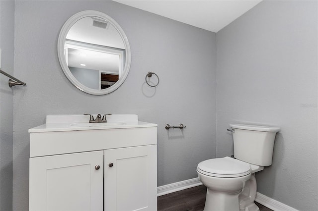 bathroom with vanity, hardwood / wood-style flooring, and toilet