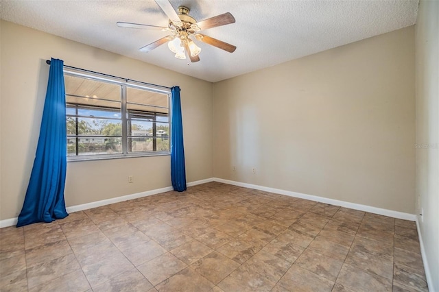 empty room with ceiling fan and a textured ceiling