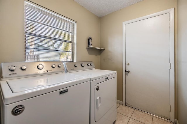 laundry room featuring light tile patterned flooring, washer and dryer, and a textured ceiling