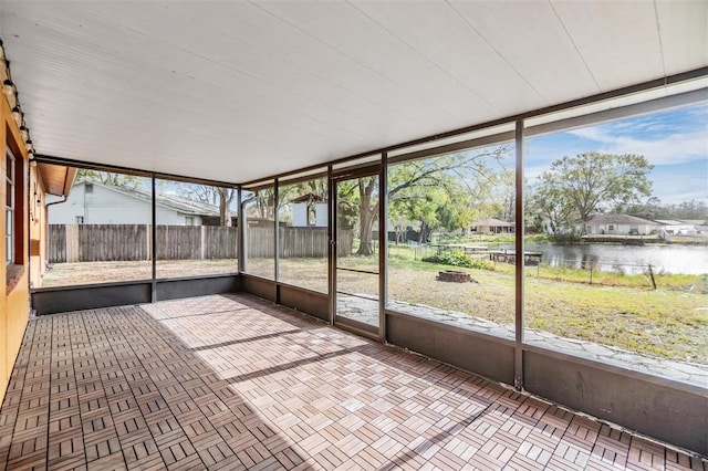 unfurnished sunroom featuring a water view