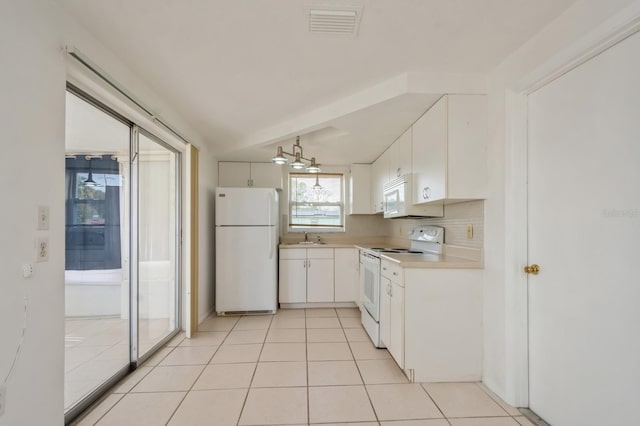 kitchen featuring sink, white appliances, white cabinetry, light tile patterned flooring, and decorative backsplash