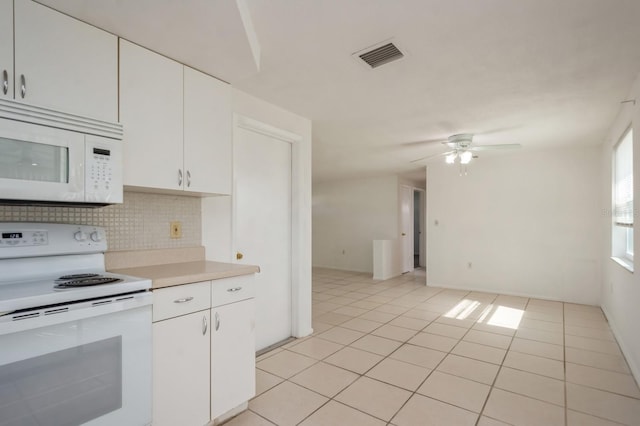 kitchen with tasteful backsplash, white cabinets, light tile patterned floors, ceiling fan, and white appliances