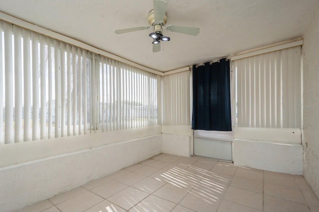 tiled empty room featuring ceiling fan